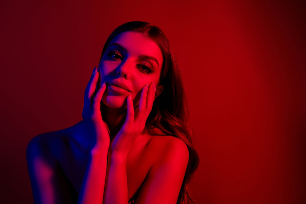 Woman using a red light therapy mask for skin rejuvenation
