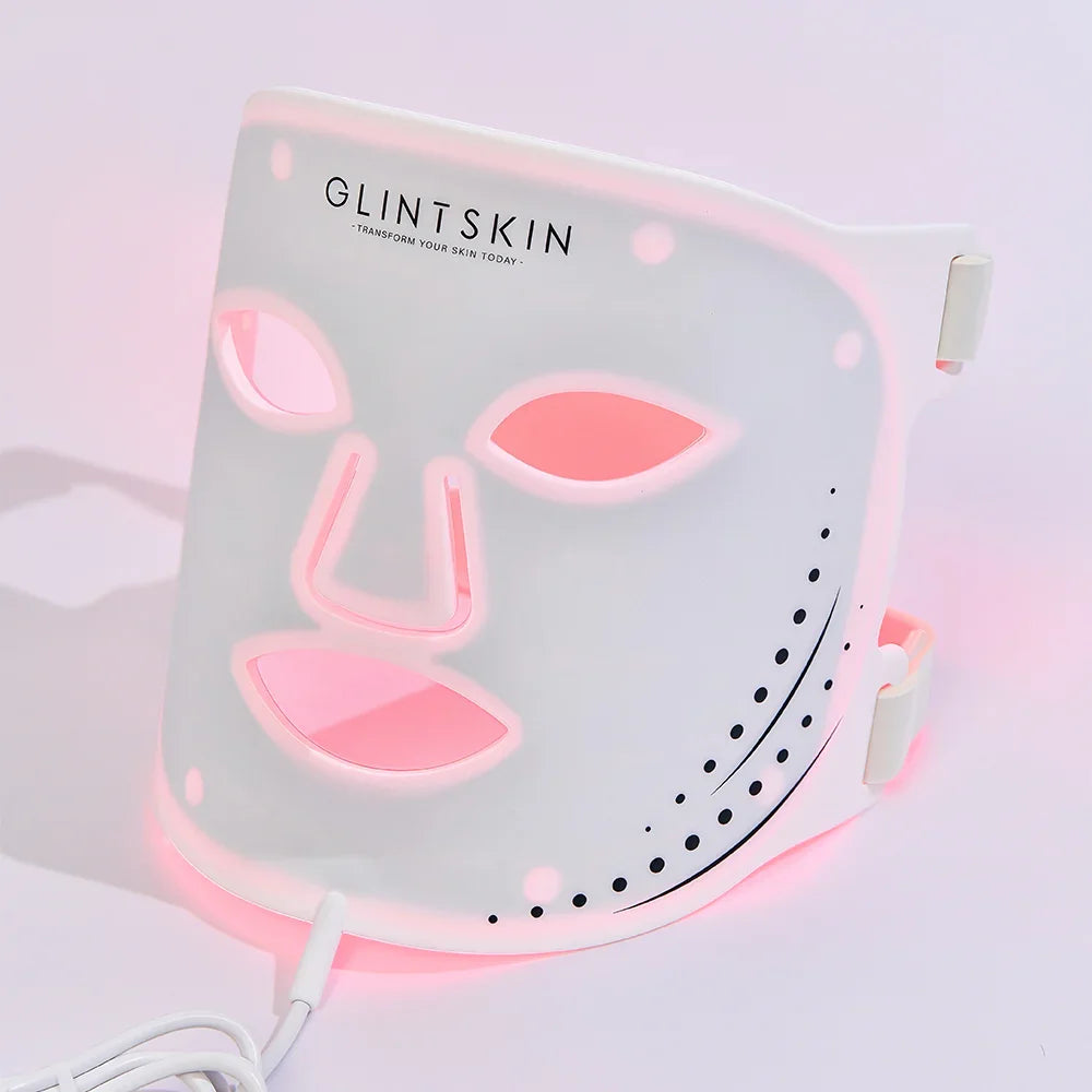 White GlintSkin LED face mask showing the face openings, side straps and front cable connection